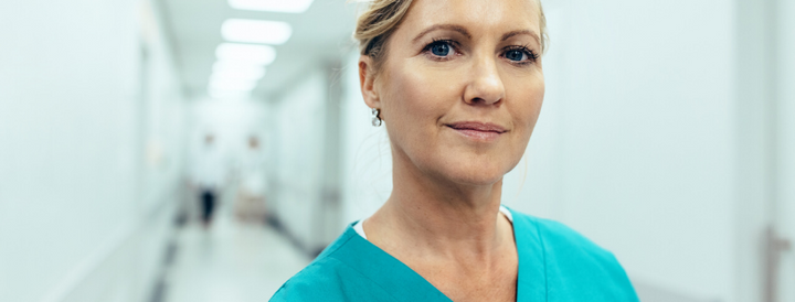 Female Healthcare Worker Standing in Hospital Corridor