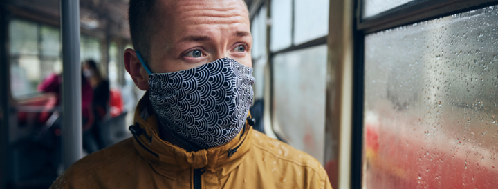 Man in a bus wearing a mask 