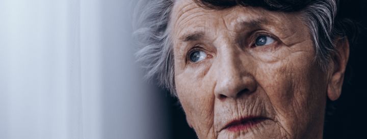 Old woman standing beside the window